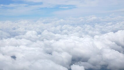 blue sky with white fluffy clouds from airplane flight fly over the clouds in a sunny day with cloud