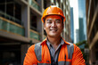 © Surachetsh - The portrait of an Asian male construction worker in a company uniform, orange safety vest and helmet, smiling and standing in front of construction site background. Generative AI.