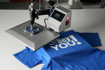 Wall Mural - Printing logo. Heat press with blue t-shirt on white table