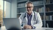 © Attasit - Doctor making video call using zoom meeting online app via laptop computer in medical office.