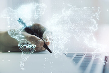 Multi exposure of abstract creative digital world map and hand writing in notebook on background with laptop, research and analytics concept