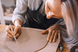 © nataliaderiabina - Female hands working with clay makes ceramic tableware on pottery workshop.