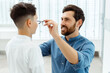 © Maria Vitkovska - Happy father and his son choosing eyeglasses in optical store