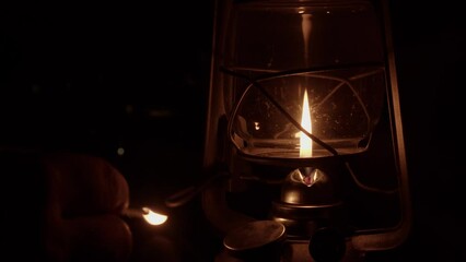 Wall Mural - At dark night campsite, kerosene oil lamp is lit with burning match