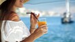 Closeup of beautiful woman drinking cocktail or juice with straw while enjoying summer vacation on the sea beach.