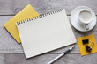 © Svetlana - Blank notepad on yellow notepad and cup of coffee on wooden table in office