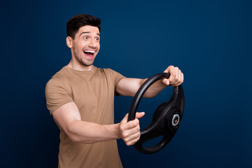 Canvas Print - Photo of excited cheerful man dressed beige clothes driving new own car looking empty space isolated on dark blue color background