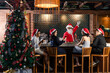 © Space_Cat - Bartender dressed like Santa serving drinks to group of friends celebrating Christmas or New Year sitting, relaxing by the bar
