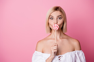 Wall Mural - Photo of sweet impressed girl dressed off shoulders outfit lollipop cover mouth empty space isolated pink color background