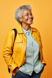 © AI_images - Smiling elderly African American IT woman 50s years old wears jacket white t-shirt hold closed laptop pc computer isolated on plain yellow background studio portrait. People lifestyle concept