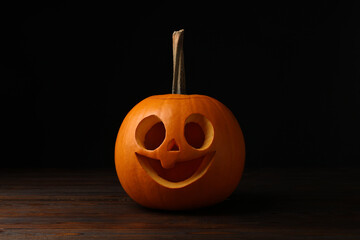 Wall Mural - Scary jack o'lantern made of pumpkin on wooden table in darkness. Halloween traditional decor