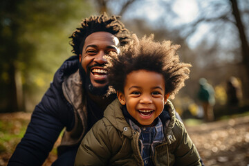 Wall Mural - Joyful African American father and son enjoying quality time together in sunny park, exemplifying family bonding and happiness in casual attire