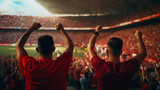 Fototapeta  - group of fans dressed in red color watching a sports event in the stands of a stadium