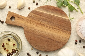 Wooden cutting board and spices on beige table, flat lay. Space for text