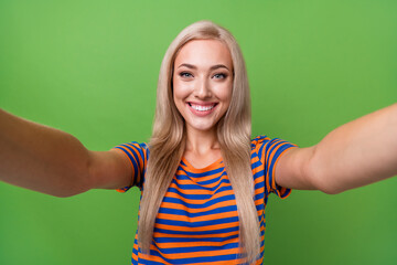 Poster - Self portrait of nice young beautiful girlfriend wear striped t shirt holding camera recording video isolated on green color background