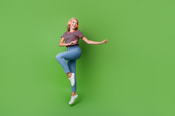 Canvas Print - Full length photo of youngster girl jumping music wireless earphones dancing at home atmosphere party isolated on green color background