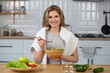 © Тетяна Шустик - Pretty young woman eating salad in the kitchen at home. Close up beautiful girl eating healthy  salad, healthy lifestyle