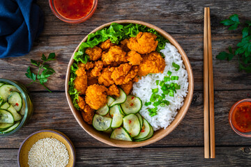 Poster - Korean fried chicken - seared breaded chicken nuggets served with white rice and vegetables on wooden table
