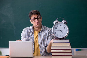 Wall Mural - Young male student in time management concept