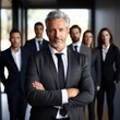 © piai - A handsome 50yo senior executive in a power suit confidently leading a diverse team