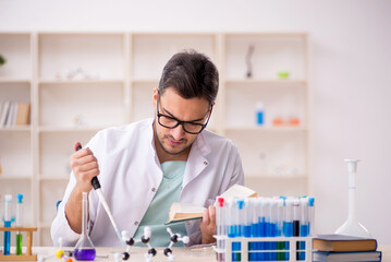 Wall Mural - Young male chemist sitting at the lab