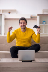 Wall Mural - Young man playing video games at home