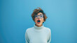 Young beautiful brunette woman wearing casual blue turtleneck sweater and glasses shouting and mad shouting and yelling with furious expression and mouth. rage. aggressive.