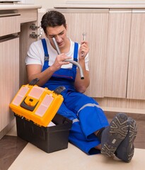 Wall Mural - Young repairman working at the kitchen