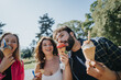 © qunica.com - Carefree friends enjoying a sunny day in the park, eating ice cream, and having fun conversations. They create joyful memories in nature, embracing the positive energy of their leisure time together.