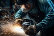 heavy machinery and power tools being used by a skilled construction Worker. He is Using Angle Grinder and throwing sparks. Contractor at work in safety gear. 