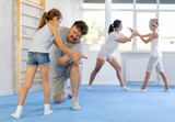 Parents and children during training and self-defense workout. Training moment of neutralizing enemy, transformation of attack into defense.