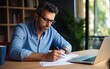 © piai - Portrait of a small business owner calculating his bills and revenue