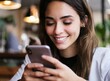 © D'Arcangelo Stock - Beautiful brunette woman using her phone texting at coffee shop, smiling face closeup