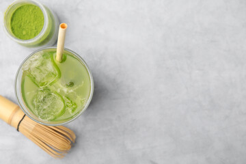 Wall Mural - Glass of delicious iced green matcha tea, powder and bamboo whisk on light grey table, flat lay. Space for text