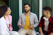 © martinkralicek - Young hipster man talks energetically to a work group.
