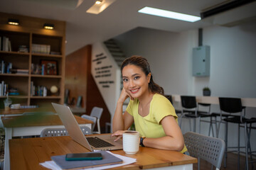 Wall Mural - Woman sitting working with laptop at coffee shop, freelance woman working outside Concept.