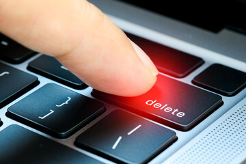  Finger of the computer user, he presses the delete button on the computer keyboard.