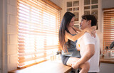 Young asian couple show each other affection in the kitchen at home. Happy family concept.