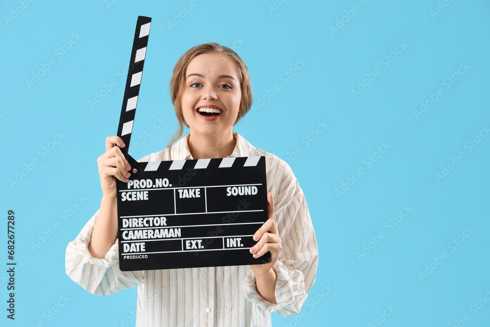 Beautiful actress with movie clapper on blue background