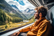 A male traveler on a train journey through a mountain pass by train and looking through the window