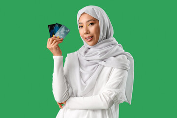 Sticker - Beautiful Muslim woman with credit cards on green background