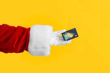 Sticker - Santa hand with credit card on yellow background, closeup