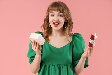 Sticker - Beautiful young shocked woman with gift box on pink background