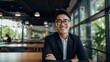 Portrait of a young handsome asian entrepreneur wearing smart glasses, smiling and looking forward to his future startup innovations - Generative AI