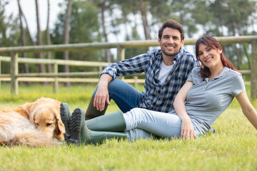 couple in a meadow with their pet dog