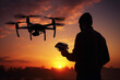 A silhouette of a standing man holds a remote controller pad and operates a drone isolated on a sunset horizontal background. Generative AI.