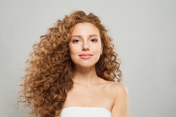 Stylish young fashion model woman with natural makeup, clear skin and curly hairstyleposing on white background