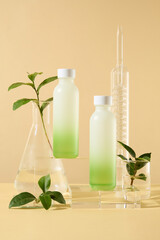 Sticker - Set of cosmetic bottles on glass podiums with green tea leaves and lab glassware on beige background. Product and promotion concept for advertising cosmetic of green tea extract. Front view