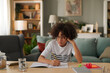 © Stockphotodirectors - Bored African American teenager doing homework without interest at home
