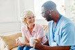 nurse doctor senior care caregiver help assistence retirement home nursing elderly woman man health support african american black coffee tea drinking cup